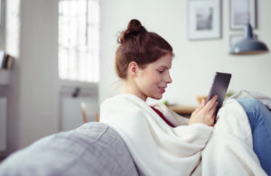 Chica sentada en el sofá con una tablet