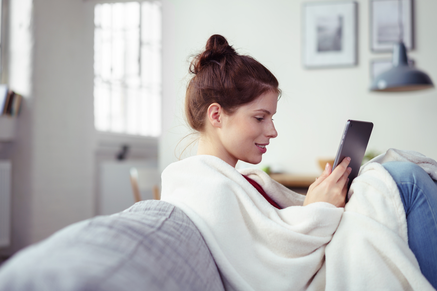 Chica sentada en el sofá con una tablet