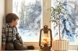 Niño sentado al lado de una ventana