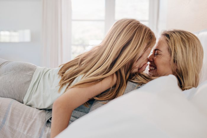 Madre e hija jugando en el dormitorio