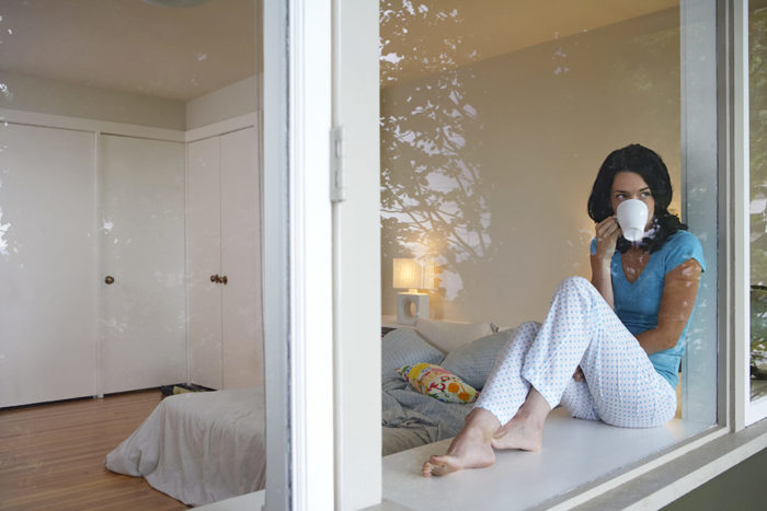 Mujer sentada al lado de la ventana